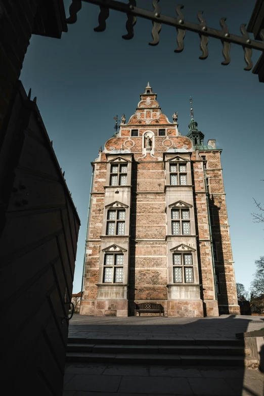 the front of an old brick building with staircases and a steeple