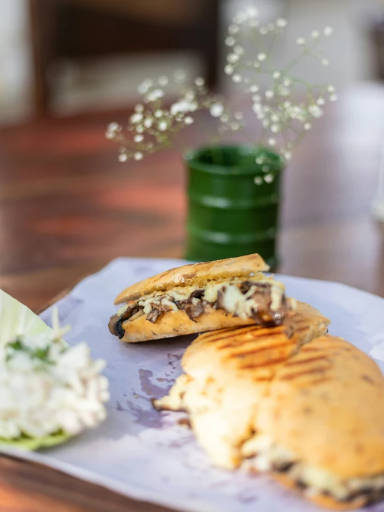 a table with sandwiches and a small bouquet of flowers