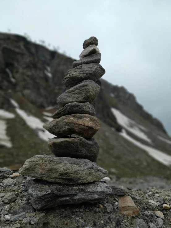a group of rocks piled on top of each other near a snowy mountain