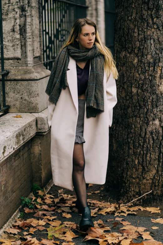 a beautiful young blond in a white coat and dress