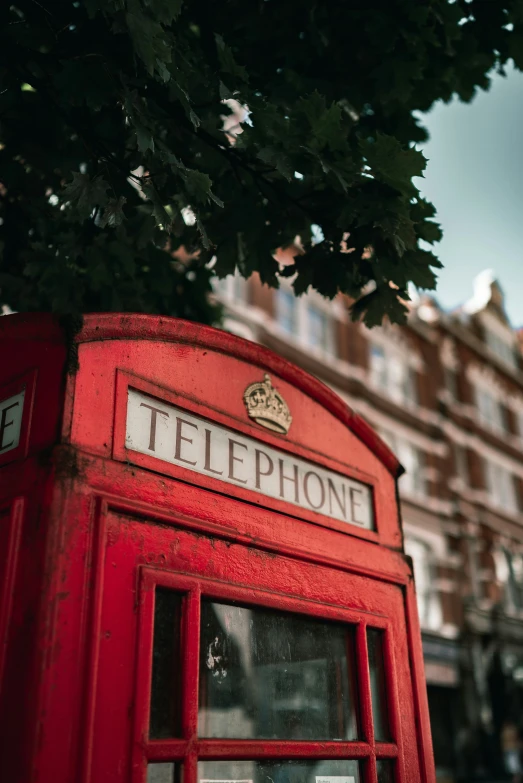 a red phone booth sitting on the side of a street