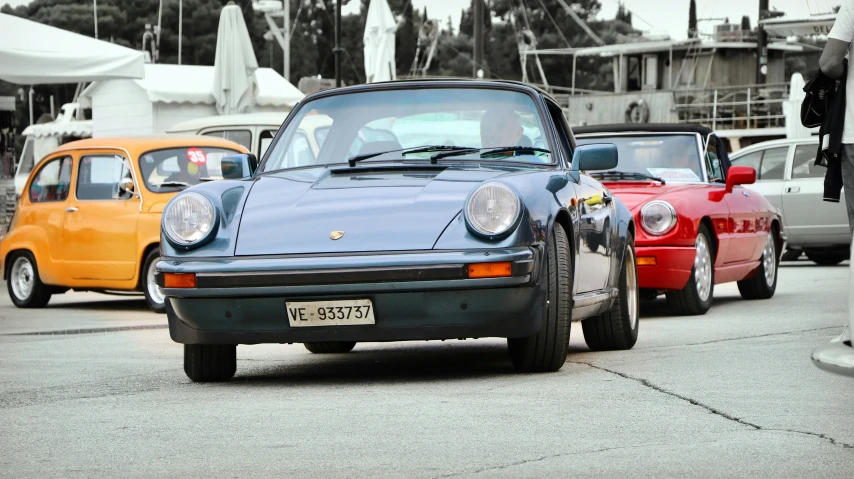 a blue porsche next to a red volkswagen type bug