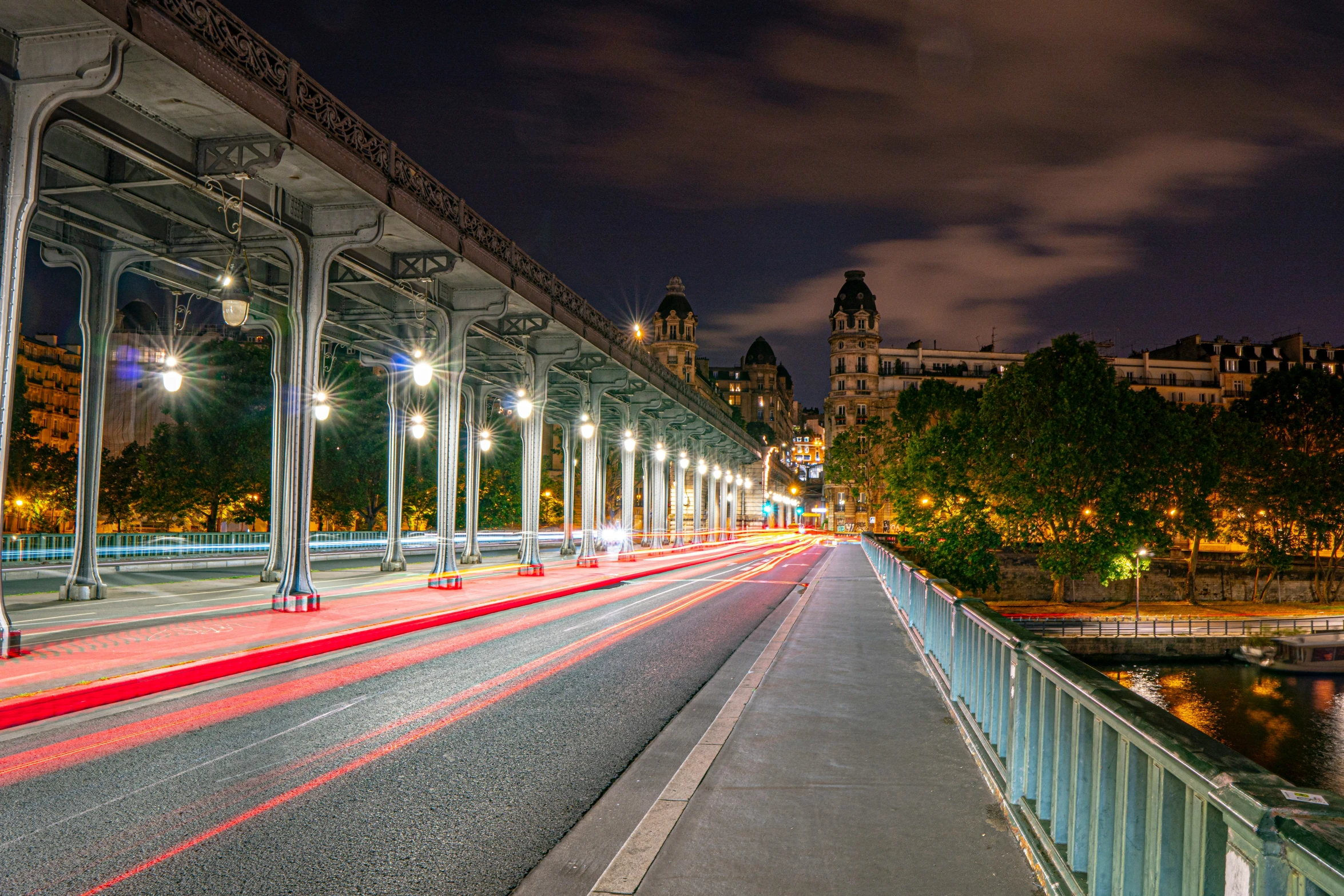 a large bridge with many arches leading down to it at night