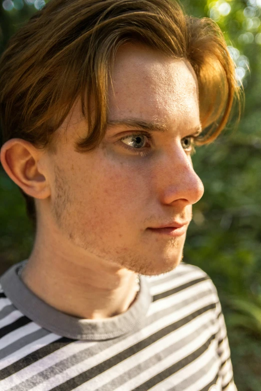 a young man with a mustache wearing a striped shirt