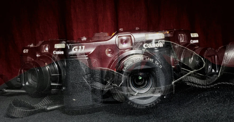 a digital camera on display with a red curtain in the background
