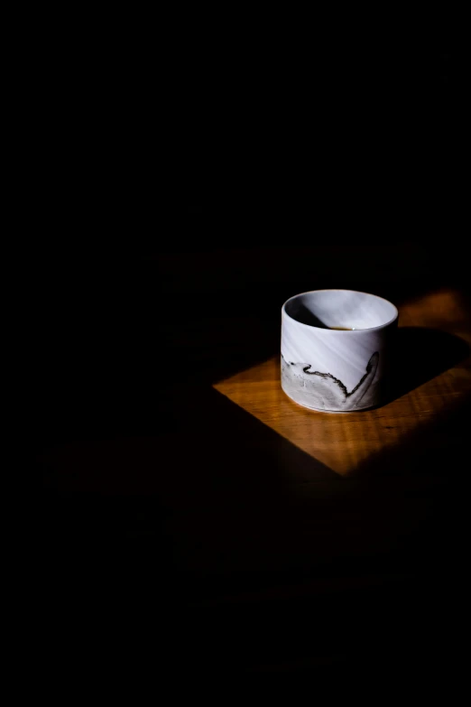 an empty bowl on a wooden table in the dark