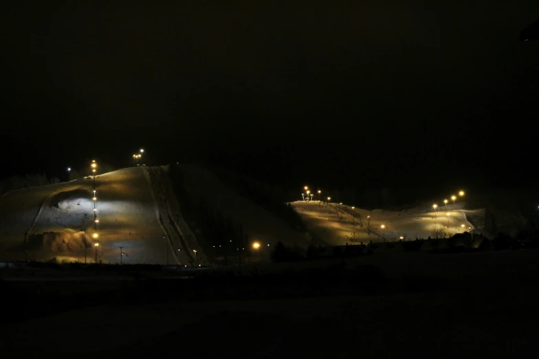 a ski slope is lit up by the lights