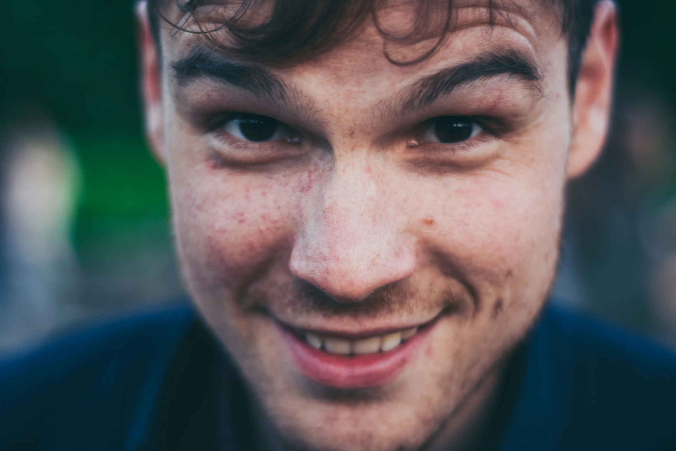 an open - faced young man has a mustache and smiles for the camera