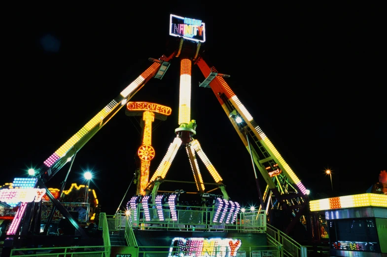 a carnival rides at night, with a light display and rides