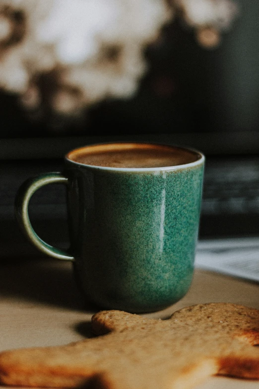 a cup of coffee sitting on top of a wooden table