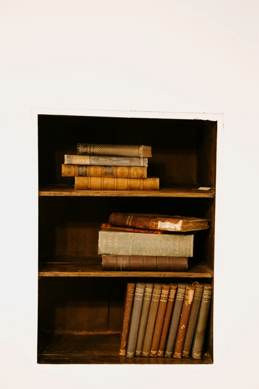 the books are stacked on top of each other in a cabinet