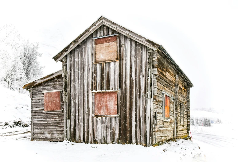 an old, rustic building covered in snow