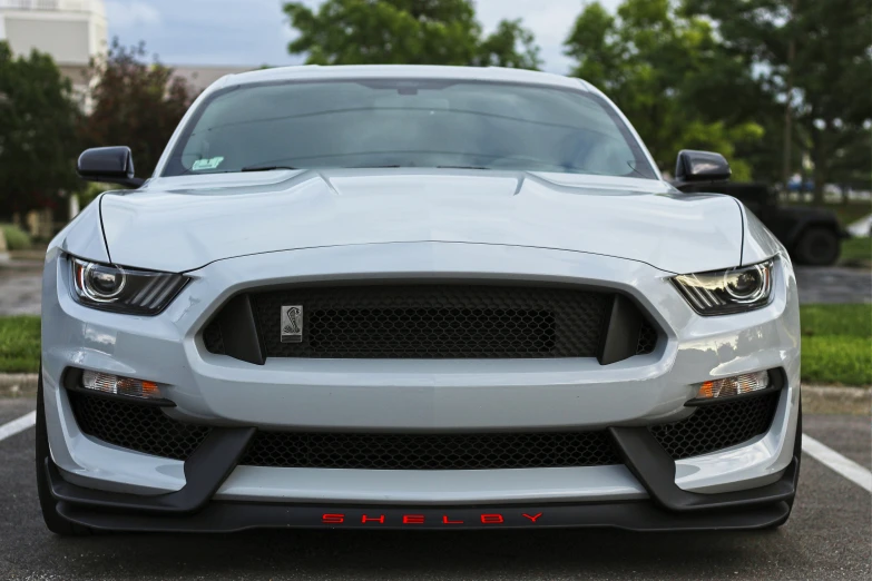 a grey mustang parked on top of a parking lot