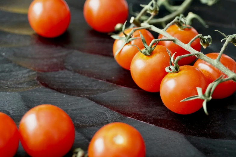 a group of red tomatoes on a vine