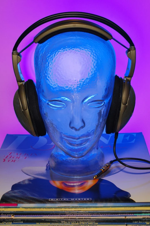 a head with headphones on is sitting beside books