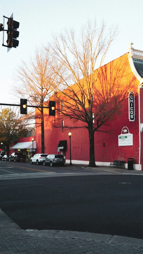 a red building next to a green traffic signal