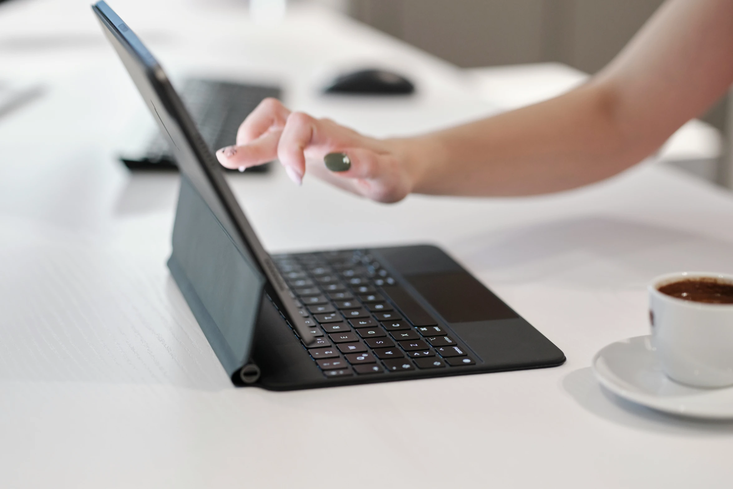 a woman holding out her hand while using her laptop