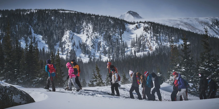 a group of snowboarders in the mountains on a cloudy day