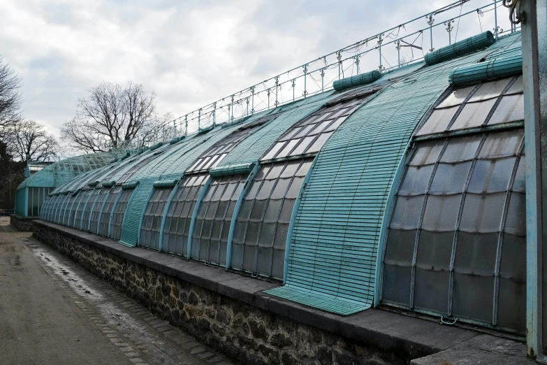 a building with a long roof near some stone