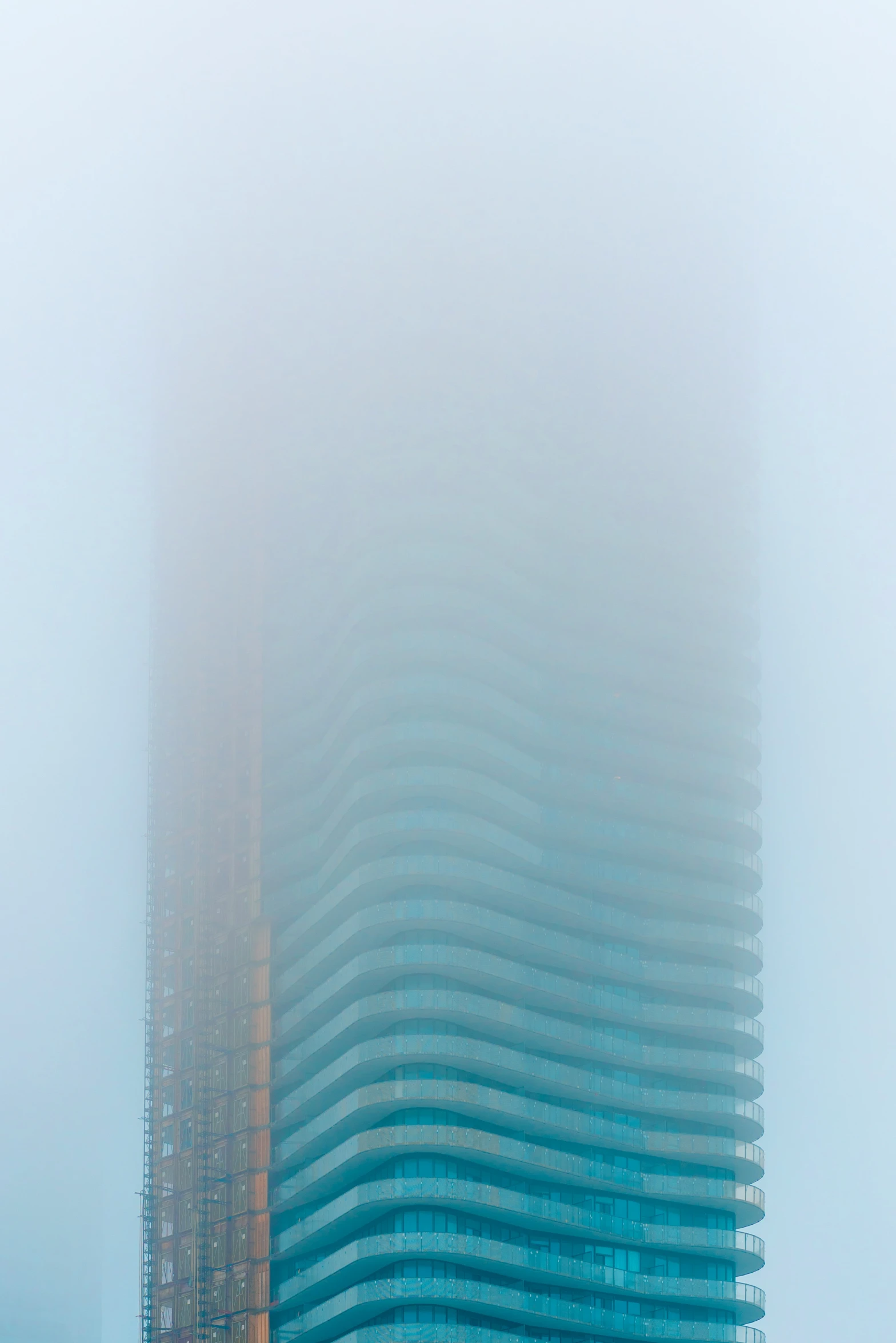 two large skyscrs on the side of a street in fog