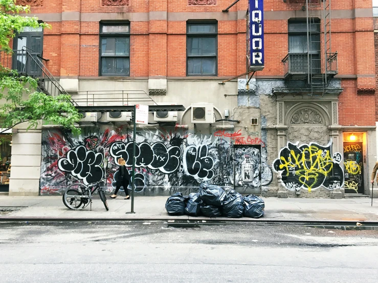 a city street that has a building covered in graffiti