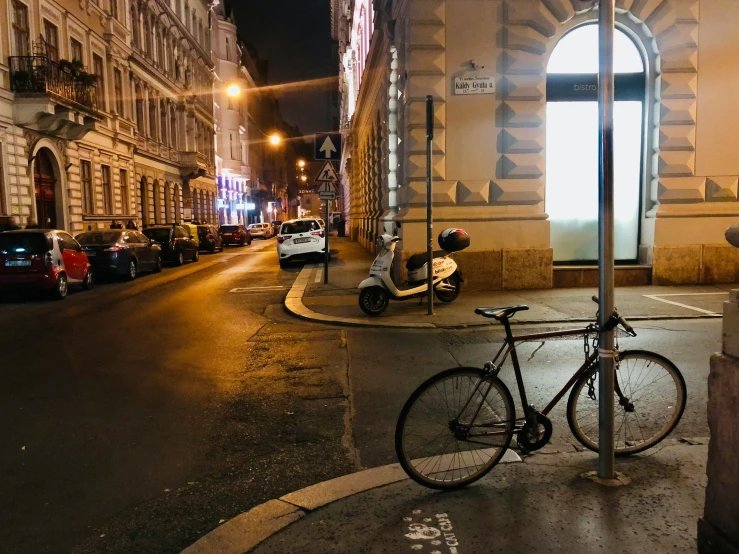 bicycle parked on a side walk with no traffic at night