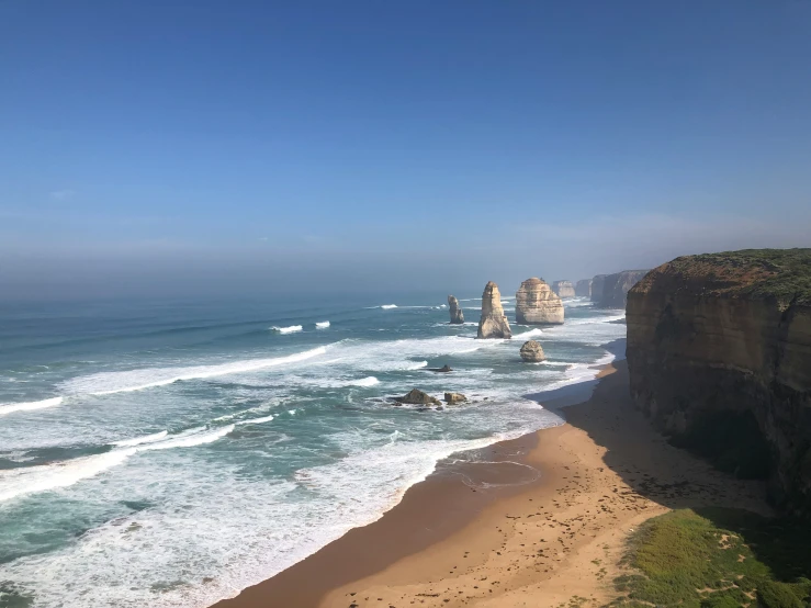 the beautiful blue ocean by the beach is dotted with cliffs