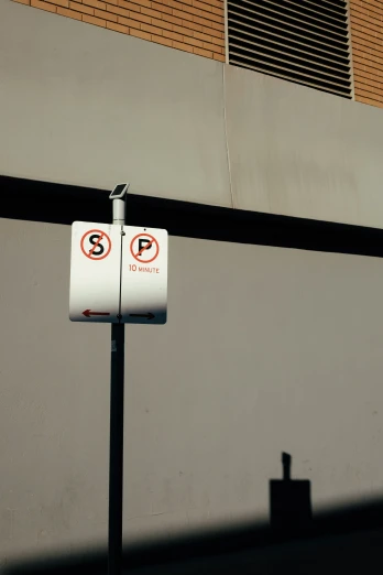 a parking sign next to the side of a building