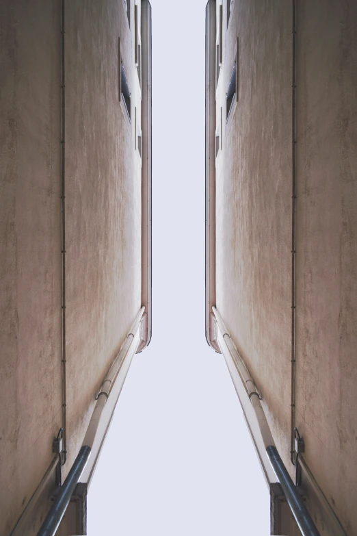 the interior of a hallway shows its long wall and metal handrails