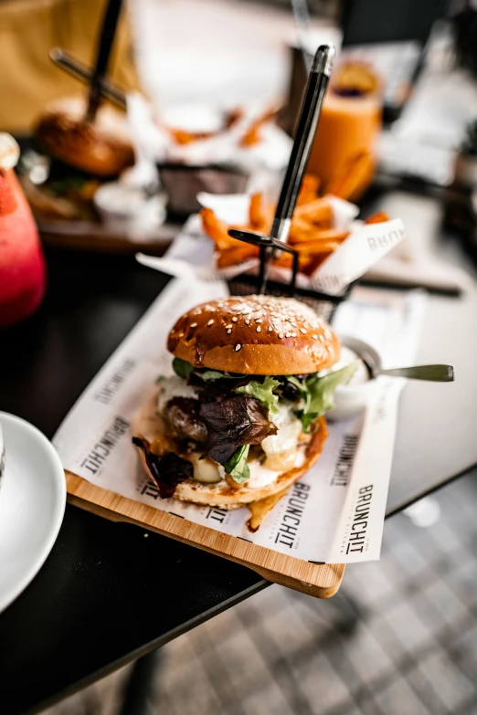 a burger with lettuce, cheese and other toppings sitting on a table