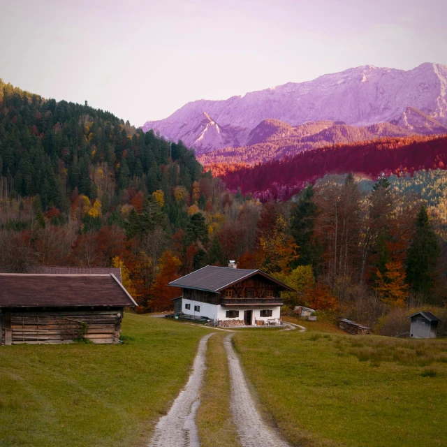 an old cottage sitting in front of some mountains