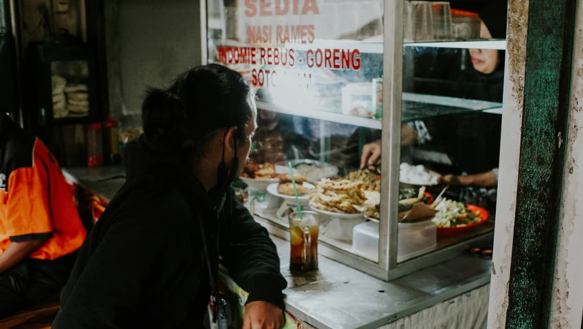 a woman standing at a counter that has food on it