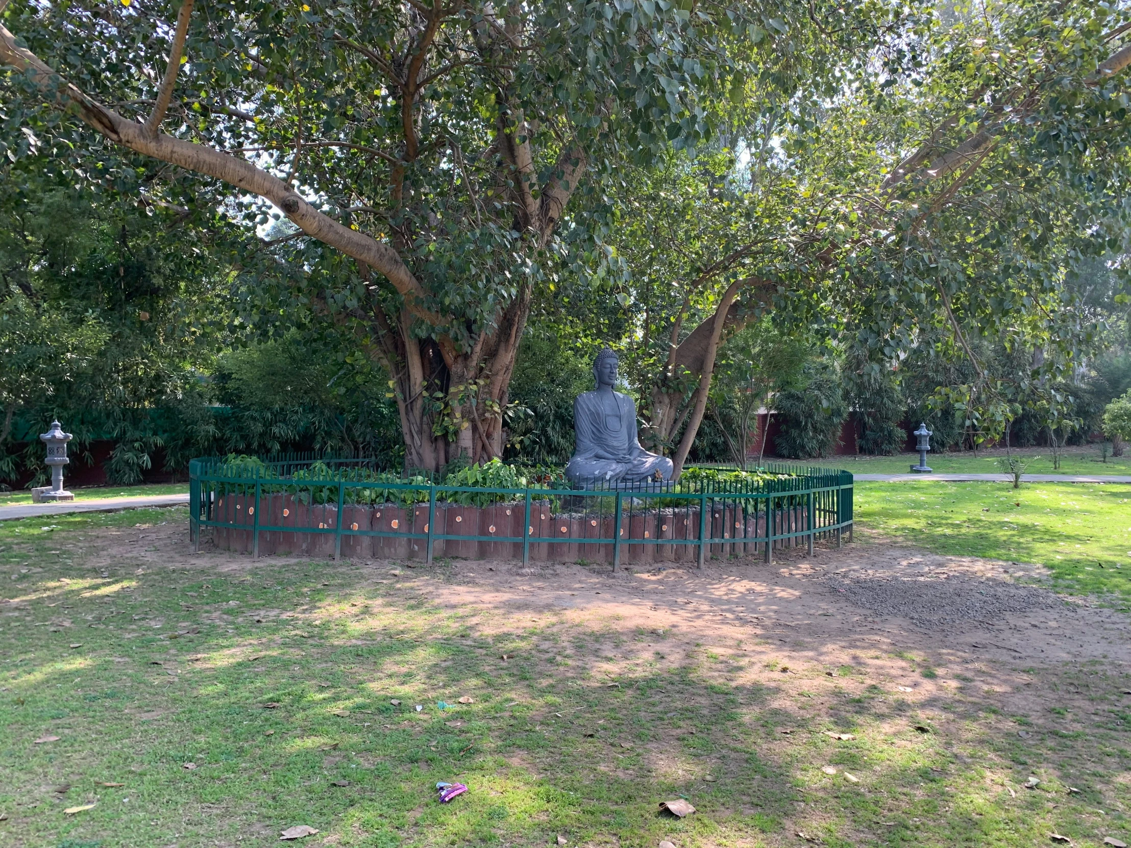 a statue sits in the middle of a tree filled park