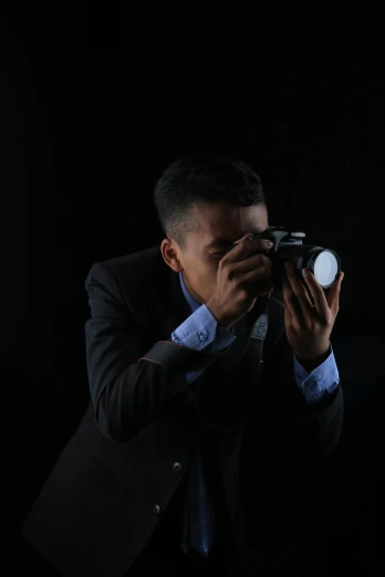 man takes pictures with camera in dark room