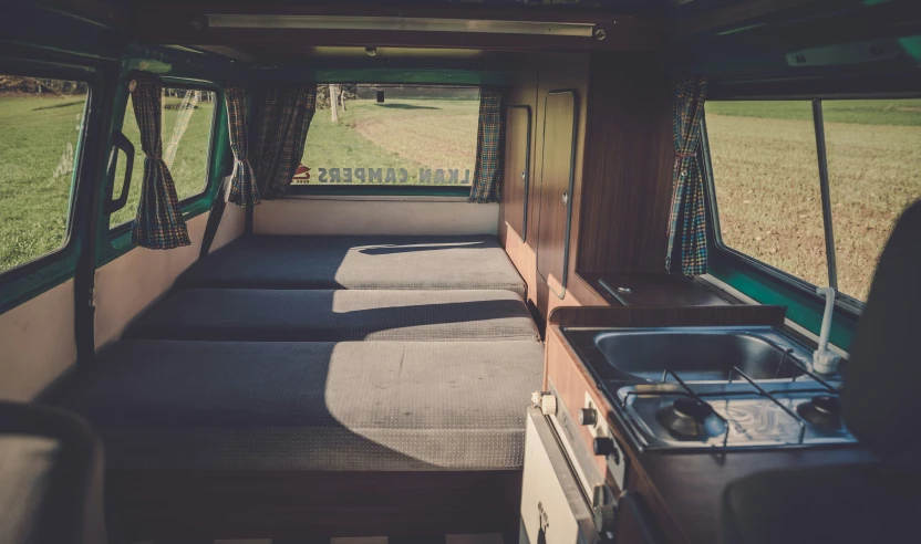 two beds and a stove inside a camper