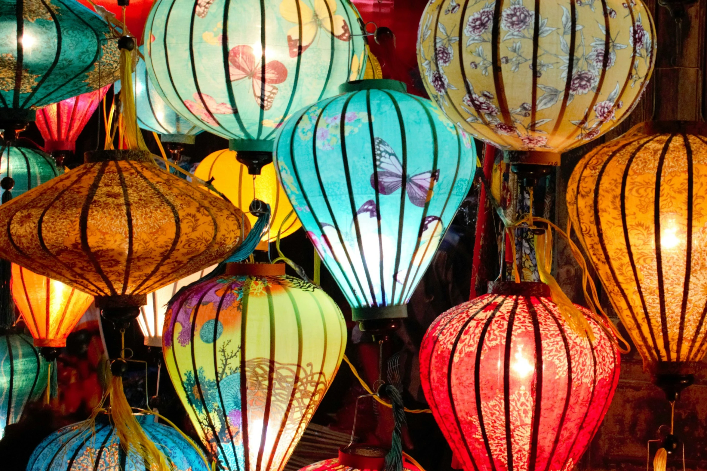 many colorful lanterns are lit on the dark street