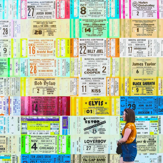 woman leaning against a wall with several numbered tickets