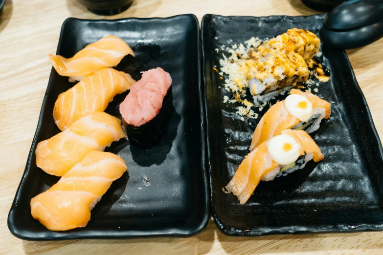 sushi dishes are ready to be served on black plates