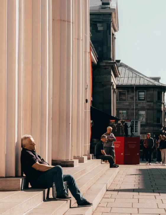 there is a man sitting on a building ledge