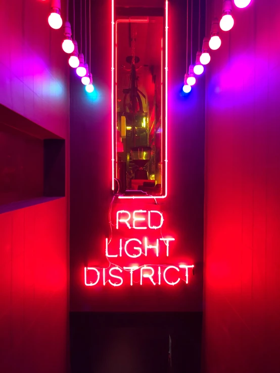 red light district sign on the side of a red wall