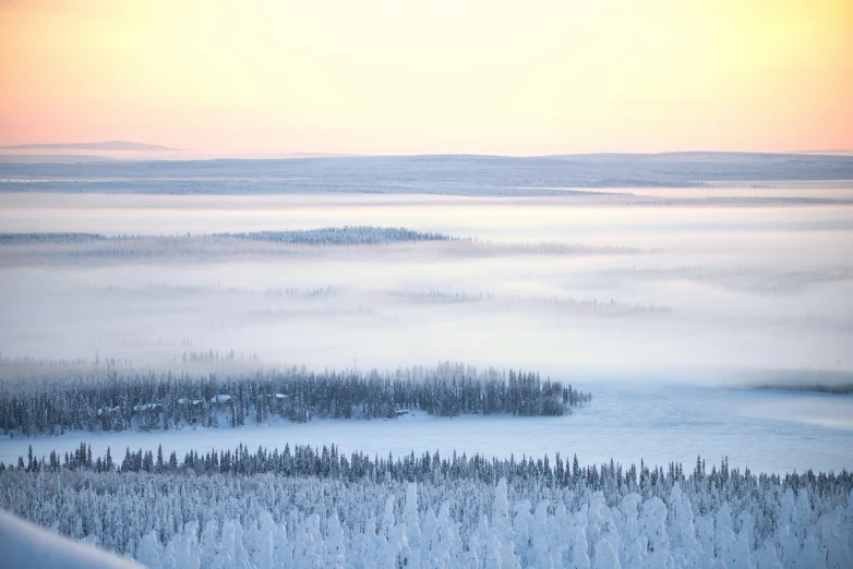 the sky has low lying fog in the foreground, looking down at a small town