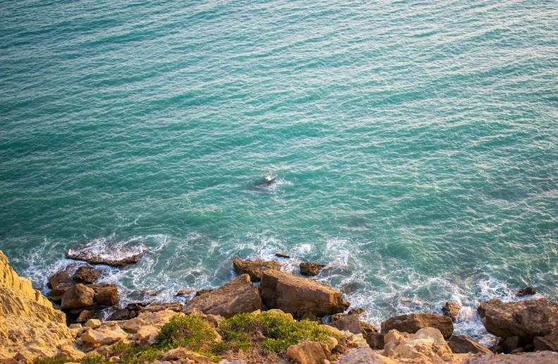 a person swimming in a lake near some rocks