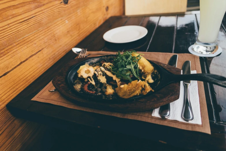 there is a dish of food sitting on a wooden tray