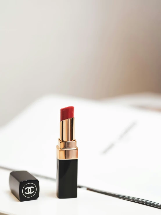 a black and red lipstick sits on top of a table
