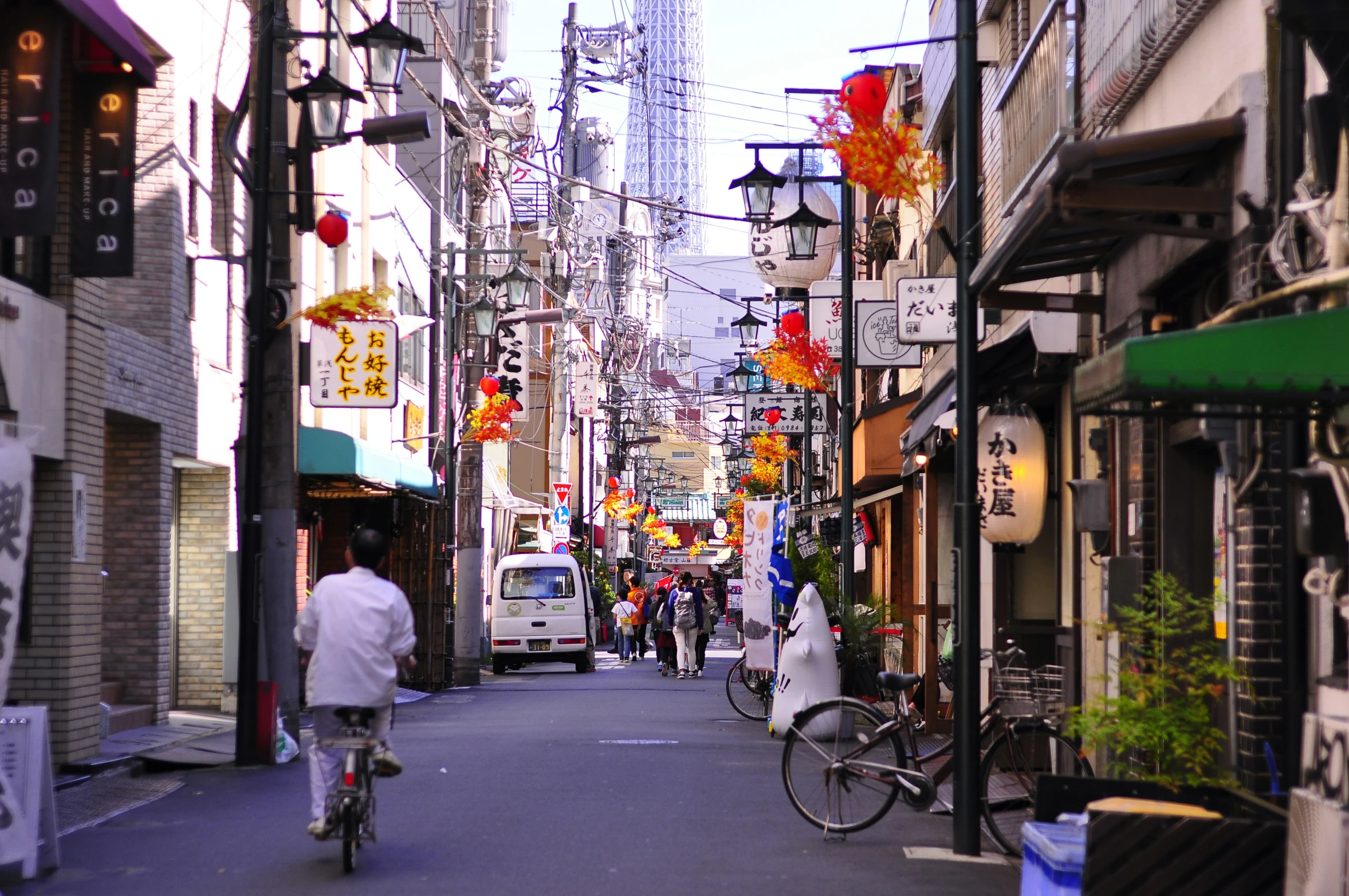 people riding bikes and bicycle down a street filled with shops