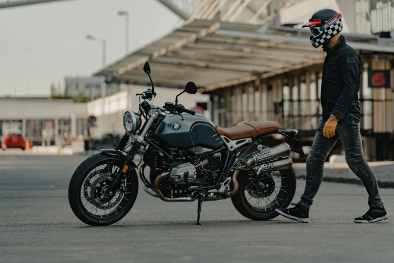 a man is walking next to his motorcycle