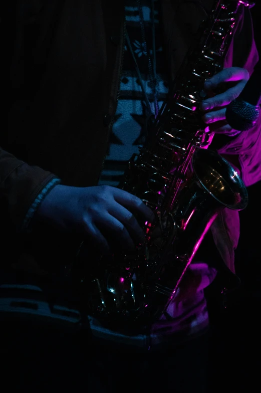 a man playing a saxophone in the dark