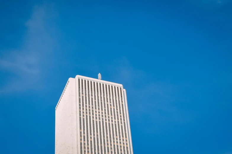 a tall white building with an interesting sky in the background