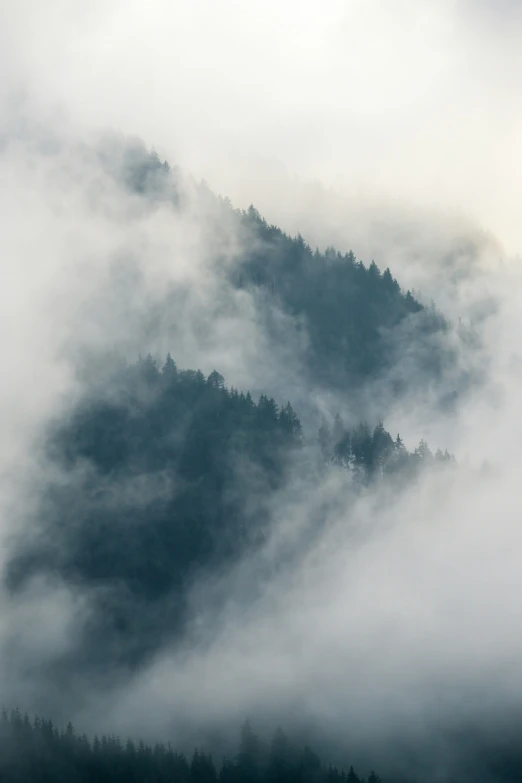 fog hangs off the tops of two mountain ranges in the distance