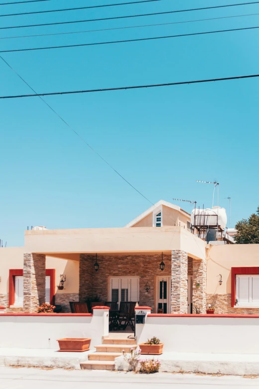 the front entrance of an upscale home sits by a long white wall